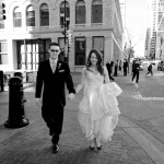 Calgary Wedding Photographer | Bride and Groom Walking by Stephen Ave. in downtown calgary