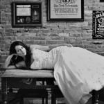 Calgary Wedding Photographer | Bride laying on pub table in the Palomino in downtown calgary