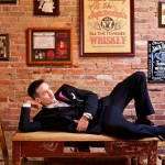 Calgary Wedding Photographer | Groom laying on pub table